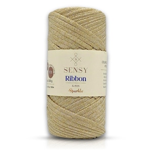 May include: A spool of gold Sensy Ribbon Sparkle yarn, 4 mm thick, made of 90% polyester and 10% polypropylene. The label reads "Sensy Ribbon 4 mm Sparkle".