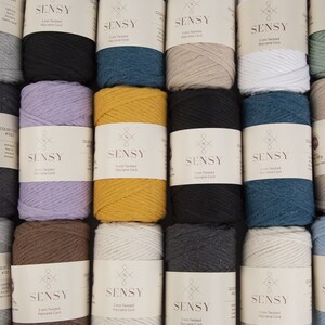 May include: A collection of 10 spools of 3mm twisted macrame cord in various colors, including black, white, brown, gray, blue, and yellow. Each spool is labeled with the brand name "SENSY" and the cord thickness.