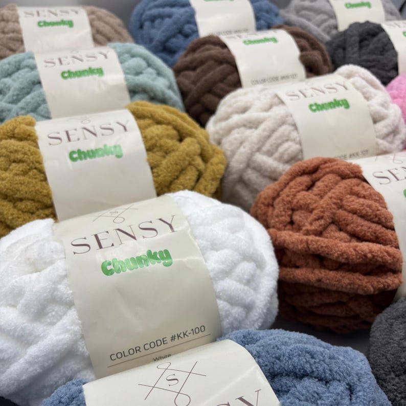 Puede incluir: Una variedad de ovillos de lana de colores con la etiqueta de la marca "SENSY Chunky". La lana es suave y esponjosa, perfecta para tejer al crochet o tejer.