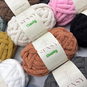 Puede incluir: Surtido de ovillos de lana de colores etiquetados como "SENSY Chunky" con c&oacute;digos de color. La lana es suave y esponjosa, perfecta para tejer al crochet o tejer.