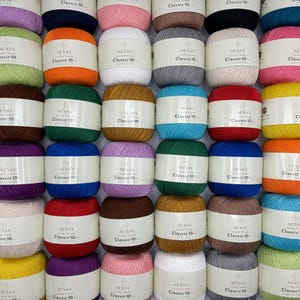 May include: A collection of 36 skeins of yarn in various colors. Each skein is labeled "SENSY Crochet Thread Classic 10".