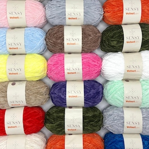 May include: A collection of 20 skeins of Sensy Velvet yarn in various colors, including pink, blue, yellow, green, red, orange, and purple. Each skein has a label with the brand name "Sensy Velvet" and a website address.