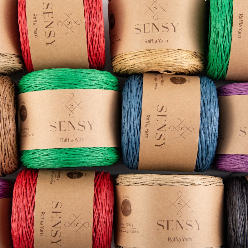 May include: Assortment of colorful raffia yarn spools with brown paper labels. Each label features the brand name "SENSY" and the text "Raffia Yarn".