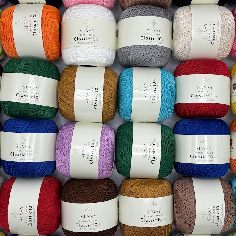 May include: A collection of 16 skeins of Sensy Classic-10 crochet thread in various colors, including red, orange, yellow, green, blue, purple, brown, and white.