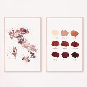 May include: Two framed art prints. One features abstract burgundy and mauve paint splatters. The other displays a palette of nine color swatches with handwritten names. Two rustic wooden bowls sit below the prints.