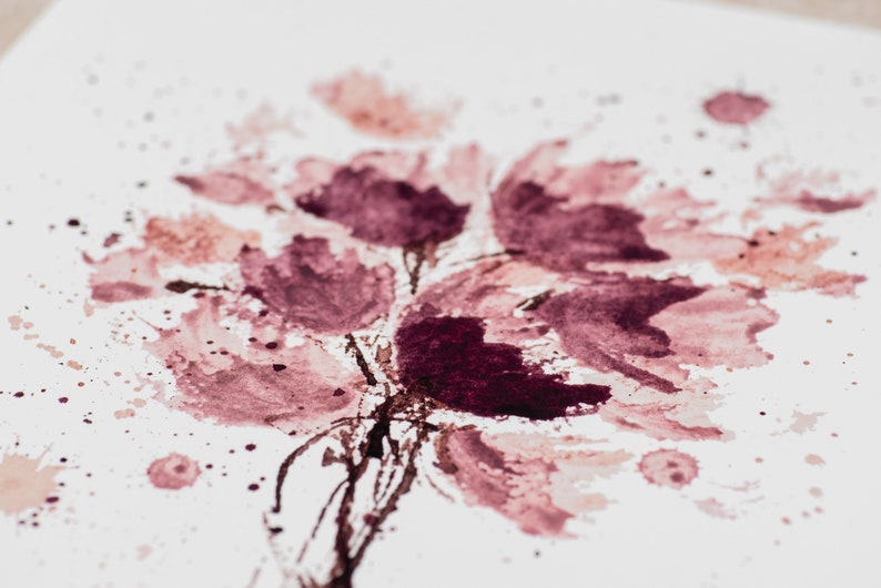 May include: Abstract watercolor painting of pink and purple flowers with splattered paint on a white background.