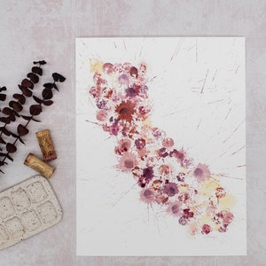 May include: A white sheet of paper with a splatter painting of red, pink, and yellow paint. The paint is in the shape of a long, thin cloud.
