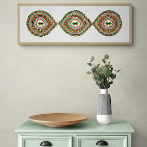 Puede incluir: Una obra de arte enmarcada con tres círculos concéntricos coloridos en forma de lágrima. Los círculos son en tonos de verde, azul, naranja y rojo. La obra de arte está colgada en una pared beige claro sobre una cómoda verde claro con seis cajones.