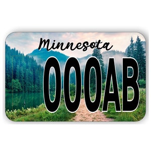 May include: A Minnesota license plate with a scenic background of a forest and lake. The plate number is 000AB.