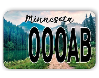 May include: A Minnesota license plate with a scenic background of a forest and lake. The plate number is 000AB.