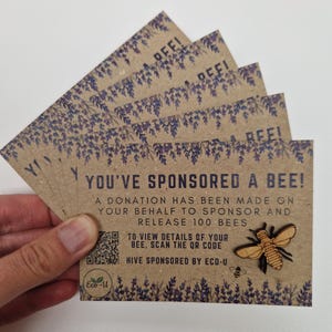May include: A brown card with a bee illustration and the text "You've sponsored a bee!" A donation has been made on your behalf to sponsor and release 100 bees. To view details of your bee, scan the QR code. Hive sponsored by Eco-U.