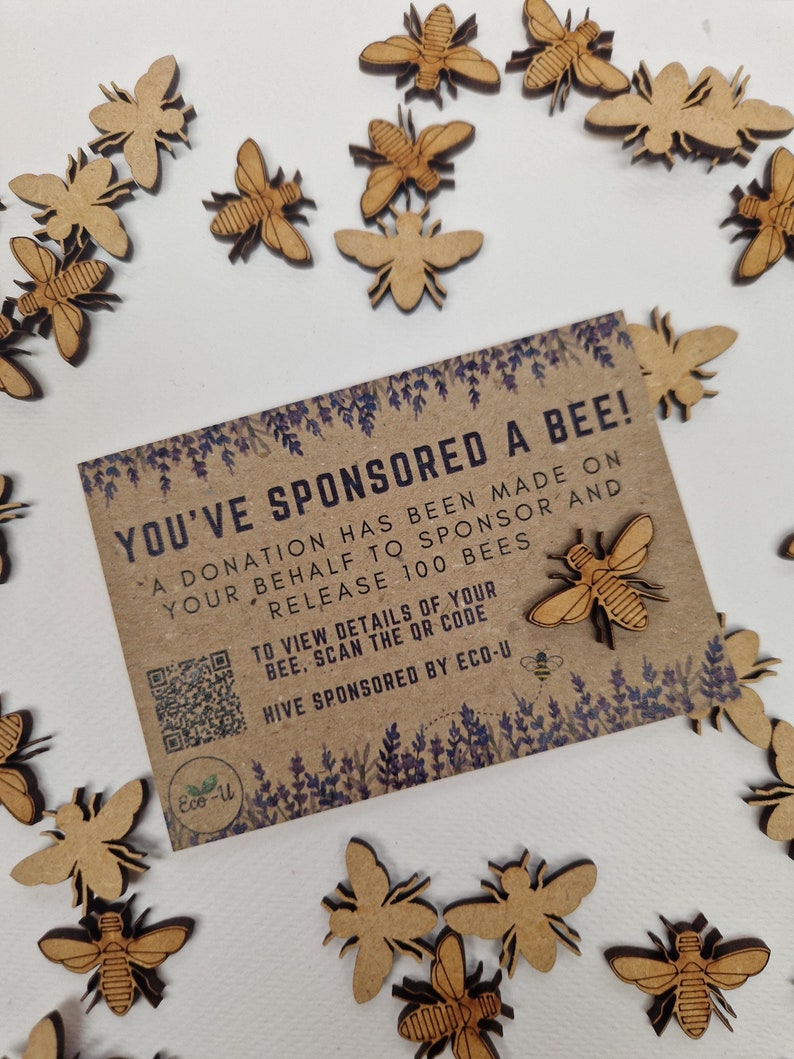 May include: A brown card with the text "You've Sponsored a Bee!" and a QR code. The card is surrounded by small wooden bee cutouts.