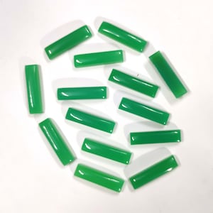 May include: A collection of twelve green rectangular cabochon gemstones. The stones are smooth and polished, with a glossy finish.