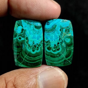 May include: Two rectangular green and blue gemstone cabochons with a swirling pattern. The cabochons are approximately 1 inch long and 1/2 inch wide.