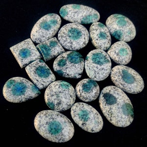 May include: A collection of 15 smooth, oval-shaped, polished stones with a white and blue speckled pattern. The stones have a light blue color with dark blue spots.