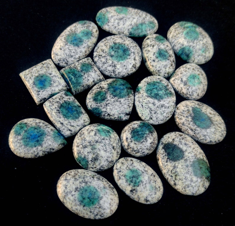 May include: A collection of 15 smooth, oval-shaped, polished stones with a white and blue speckled pattern. The stones have a light blue color with dark blue spots.