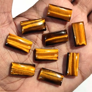 May include: Nine rectangular tiger's eye gemstones in various shades of brown and gold.
