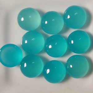 May include: Ten round, smooth, turquoise cabochons. The cabochons are polished and have a translucent appearance.
