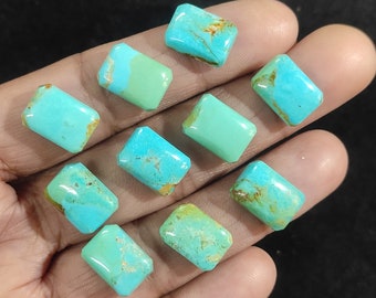 May include: A collection of ten turquoise gemstones, each with a rectangular shape and polished surface. The stones display a range of blue-green hues with brown matrix patterns. The gemstones are held in a hand against a dark background.