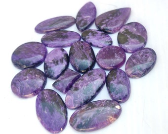 May include: A collection of 14 purple and black gemstone cabochons. The stones are smooth and polished, with a variety of shapes and sizes.