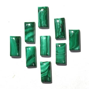 May include: Ten green malachite cabochons, each cut in a rectangular shape. The stones have a variety of patterns and shades of green.