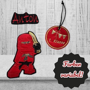Könnte beinhalten: Roter und schwarzer gestickter Aufnäher eines Ninjas mit einem Schwert, ein schwarzer Aufnäher mit dem Namen Anton, ein roter und goldener gestickter Kreis mit dem Text "1. Klasse" und ein schwarzer Stern mit dem Text "Farben variabel!"