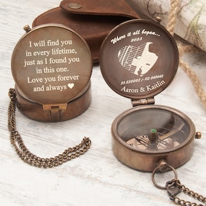 May include: Two antique brass compasses with engraved messages. One reads "I will find you in every lifetime...Love you forever and always." The other says "Where it all began...2023" with a heart-shaped design and names.