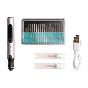 May include: A silver electric nail drill with a digital display and a USB charging cable. The drill comes with a set of 20 assorted drill bits in a clear plastic case and two additional drill bits in individual clear plastic cases.
