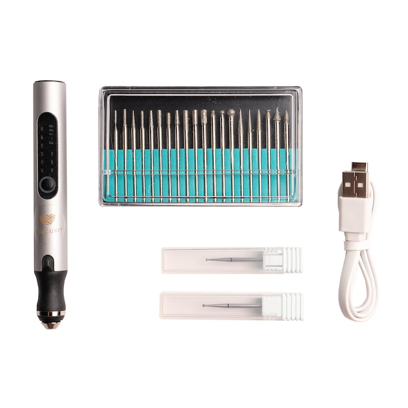 May include: A silver electric nail drill with a digital display and a USB charging cable. The drill comes with a set of 20 assorted drill bits in a clear plastic case and two additional drill bits in individual clear plastic cases.