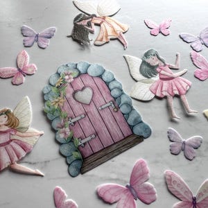 May include: A set of fairy door and butterfly decorations. The door is pink with a heart-shaped window and is surrounded by green vines and flowers. The butterflies are in various shades of pink, purple, and yellow.