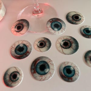 Puede incluir: Un conjunto de 10 adornos comestibles para pasteles con forma de ojo, con detalles realistas, que incluyen iris azules, vasos sangu&iacute;neos rojos y pupilas negras. Los adornos son perfectos para agregar un toque espeluznante a los postres de Halloween.