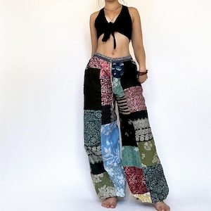 Puede incluir: Pantalones de patchwork con una variedad de colores y patrones, incluyendo negro, verde, azul, rojo y blanco. Los pantalones tienen una pierna ancha y una cintura con cordón.