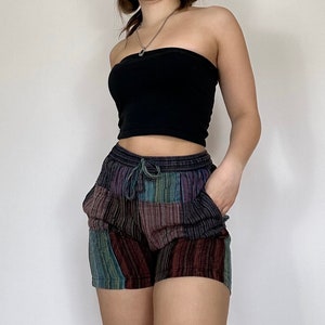 Peut inclure: Une personne portant un haut noir sans bretelles et un short patchwork coloré avec une taille à cordon.