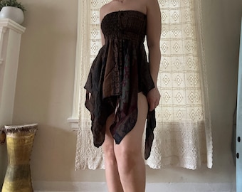 Puede incluir: Un vestido marrón y negro sin tirantes con un diseño estampado. El vestido tiene un corpiño ajustado y una falda fluida.