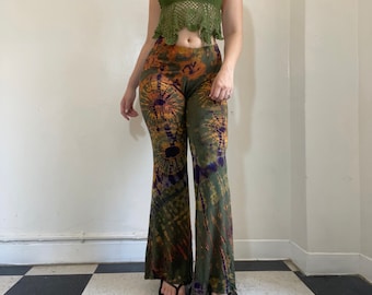 May include: A pair of green, orange, and purple tie-dye bell bottom pants. The pants have a wide leg and are made of a soft, stretchy fabric.