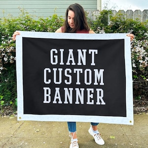 May include: A person holding a black banner with white text that reads "GIANT CUSTOM BANNER".