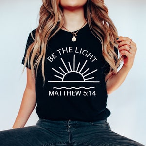 Sé la camisa ligera, camisa cristiana, camiseta religiosa, traje de fe, camiseta de Mateo 5:14, camiseta del versículo bíblico, regalo para los cristianos, regalo para ella, camiseta de la iglesia