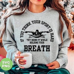 May include: Gray sweatshirt with a black graphic that says "If you think your sport is hard try doing it while holding your breath". The graphic also includes a silhouette of a swimmer.