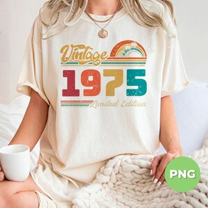 Puede incluir: Una camiseta blanca con un gr&aacute;fico de estilo vintage que dice "Vintage 1975 Limited Edition". El gr&aacute;fico presenta un arco&iacute;ris con una palmera y un sol.