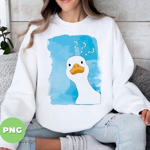 May include: A white sweatshirt with a blue watercolor design featuring a cartoon goose with a confused expression and question marks above its head. The text '??' is printed on the sweatshirt.