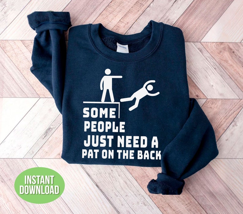 Pu&ograve; includere: Felpa blu navy con grafica bianca di due omini stilizzati e la scritta "SOME PEOPLE JUST NEED A PAT ON THE BACK." Un cerchio verde con le parole "INSTANT DOWNLOAD" si trova in basso a sinistra.