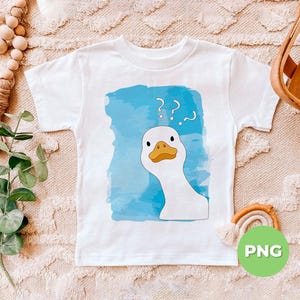 May include: A white t-shirt with a blue watercolor background and a cartoon white goose with a yellow beak and black eyes. The goose has question marks above its head. The t-shirt has the word 'PNG' in green text on a white circle in the lower right corner.