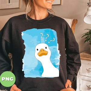May include: A black sweatshirt with a white duck cartoon wearing a confused expression. The duck is surrounded by a blue watercolor background with question marks. The text on the sweatshirt reads '???'. 
