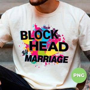 Może przedstawiać: Kremowy t-shirt z napisem "BLOCK HEAD BY MARRIAGE" w kolorze czarnym, obramowanym na niebiesko. Tekst umieszczono na tle kolorowego wzoru rozprysków w kolorze różowym, niebieskim, żółtym i zielonym. Odzież codzienna.