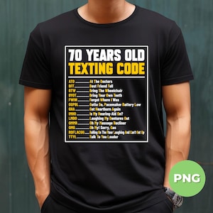 May include: Black t-shirt featuring the text "70 YEARS OLD TEXTING CODE" in white and yellow. The shirt displays a list of texting abbreviations and their meanings, including "BTW - Bring The Wheelchair" and "OMG - Oh My! Sorry, Gas."