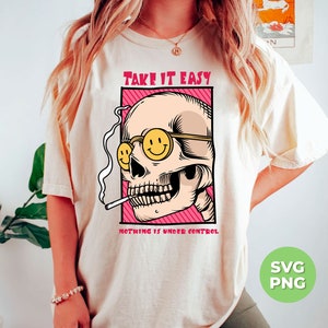 May include: A white t-shirt with a graphic of a skull wearing sunglasses and smoking a cigarette. The text "TAKE IT EASY" is above the skull and "NOTHING IS UNDER CONTROL" is below the skull.