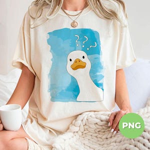 May include: A white t-shirt with a blue watercolor background and a cartoon goose with question marks above its head. The text on the shirt reads '???'.