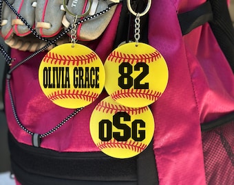 May include: Three yellow softball-shaped keychains with black stitching. One keychain says "Olivia Grace", another says "82", and the last one says "OSG".