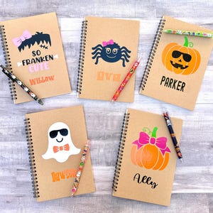Puede incluir: Cinco cuadernos con espiral con dise&ntilde;os de Halloween. Cada cuaderno presenta un gr&aacute;fico diferente: un Frankenstein, una ara&ntilde;a, una calabaza, un fantasma y una calabaza. Cada cuaderno tiene un nombre impreso y va acompa&ntilde;ado de un bol&iacute;grafo a juego.