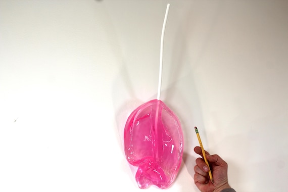 Resin sucker melting down the wall hot pink art sculpture 21 inches tall Dali inspired find out more.